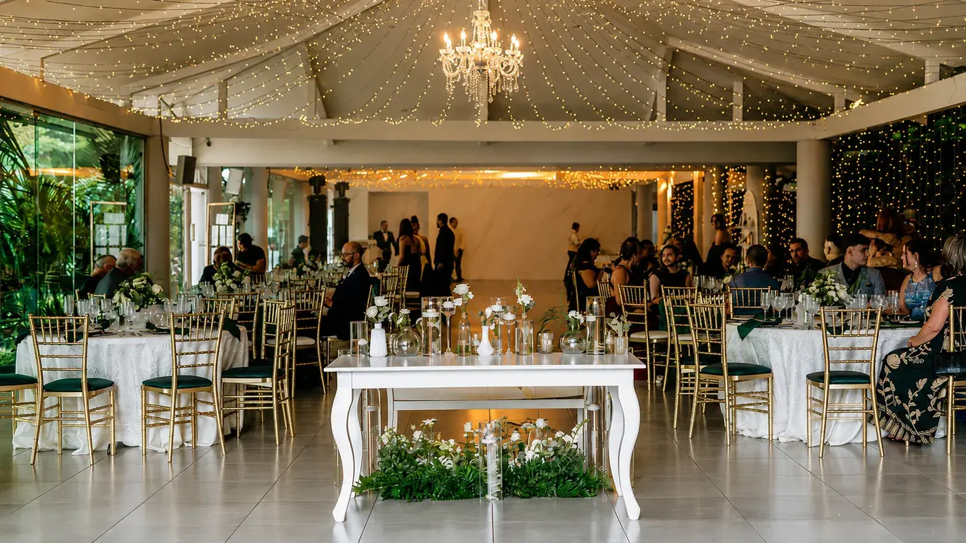 El salón de Laureal lleno de invitados durante una boda, bajo la araña de cristal