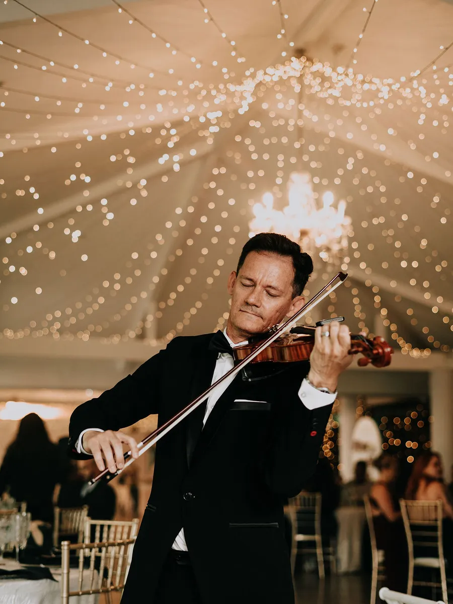 Violinista tocando en vivo bajo el techo de luces del salón de Laureal