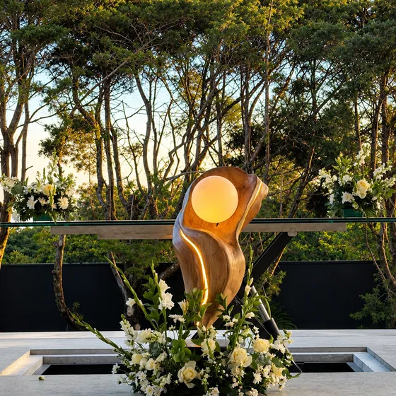 Escultura dorada iluminada y arreglo floral en la terraza de Nebulae