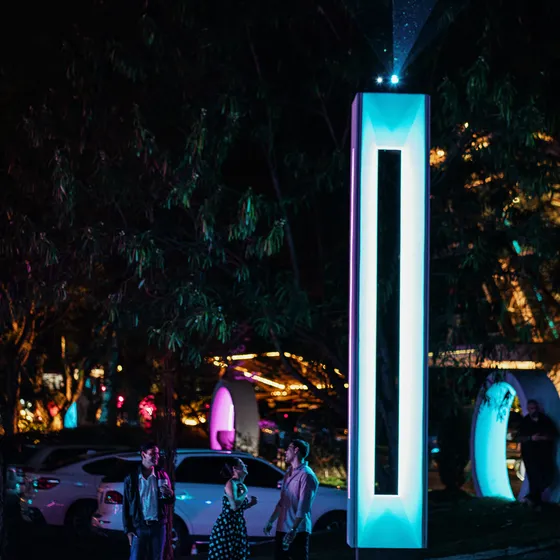 Monolito iluminado en los jardines de Nebulae durante un evento nocturno