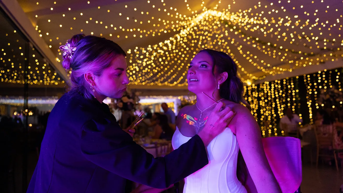 Novios abrazados bajo el cielo de luces cálidas del salón de Laureal