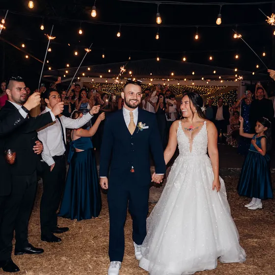 Salida de los novios entre bengalas encendidas al final de la fiesta